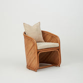 Grace dining chair with sculptural rattan frame and removable upholstered cushions, side view.